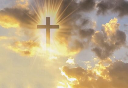 Picture of Christian cross appears bright in the gold sky in the page Easter invokes grand themes